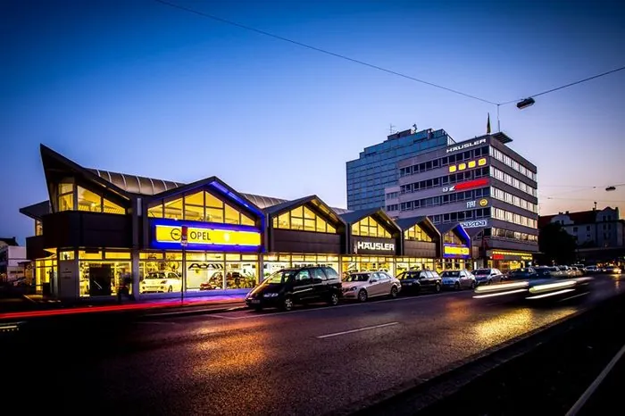 Bild des Gebäudes in München in Abenddämmerung, Autos stehen vor dem Gebäude